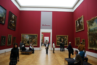 red room in museum with framed paintings