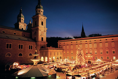 town square with market stalls and lit-up Christmas tree