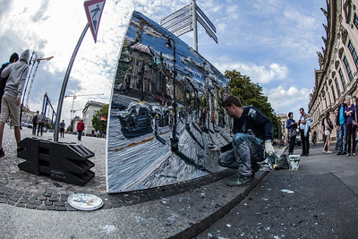 artist spray painting mural on a wall
