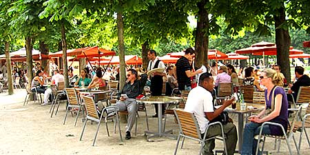 people drinking at tables in park