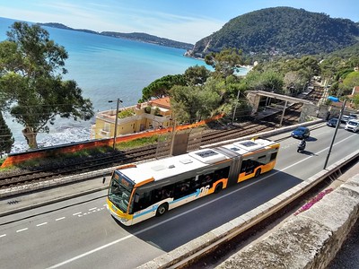 bus driving by bright blue waters