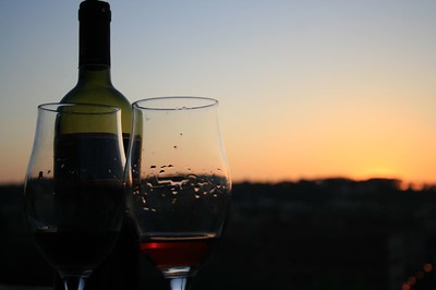 wine glasses and wine bottle with sunset in background
