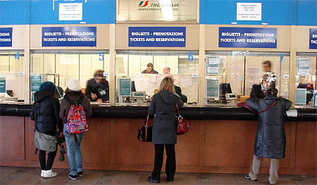 people standing in line to buy train tickets