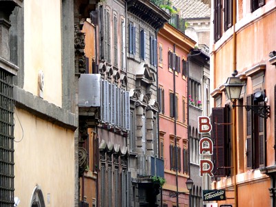 narrow street in Rome with one building displaying a sign that reads "Bar"