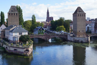 boat, bridge and old buildings near water in Strasbourg