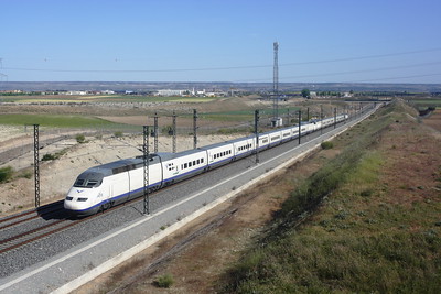 long white train driving through green landscape