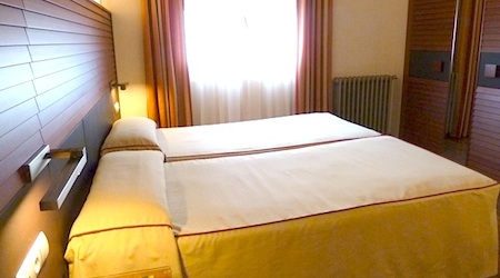yellow beds in beige room at Hotel Astoria Barcelona