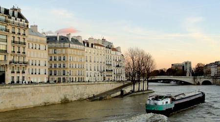 boat sailing by old buildings in Ile St-Louis Paris