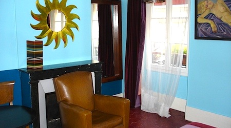 Hotel Eldorado guestroom with blue walls and a leather chair