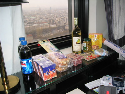 food on long table in front of hotel window with view of Eiffel Tower