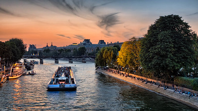 Bateaux Mouches sailing down Seine at sunset