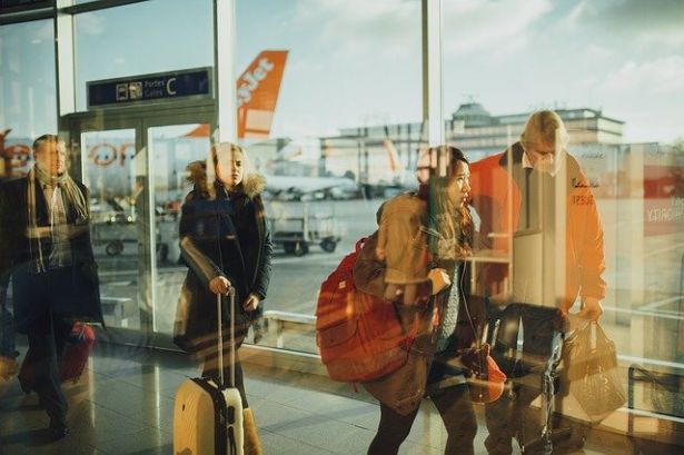 people with bags in line at airport