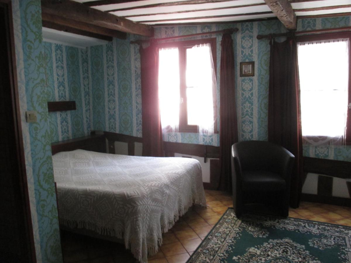 hotel room with double bed, floral wallpaper and wood beamed ceilings at Hotel Stella, one of several super cheap hotels in paris