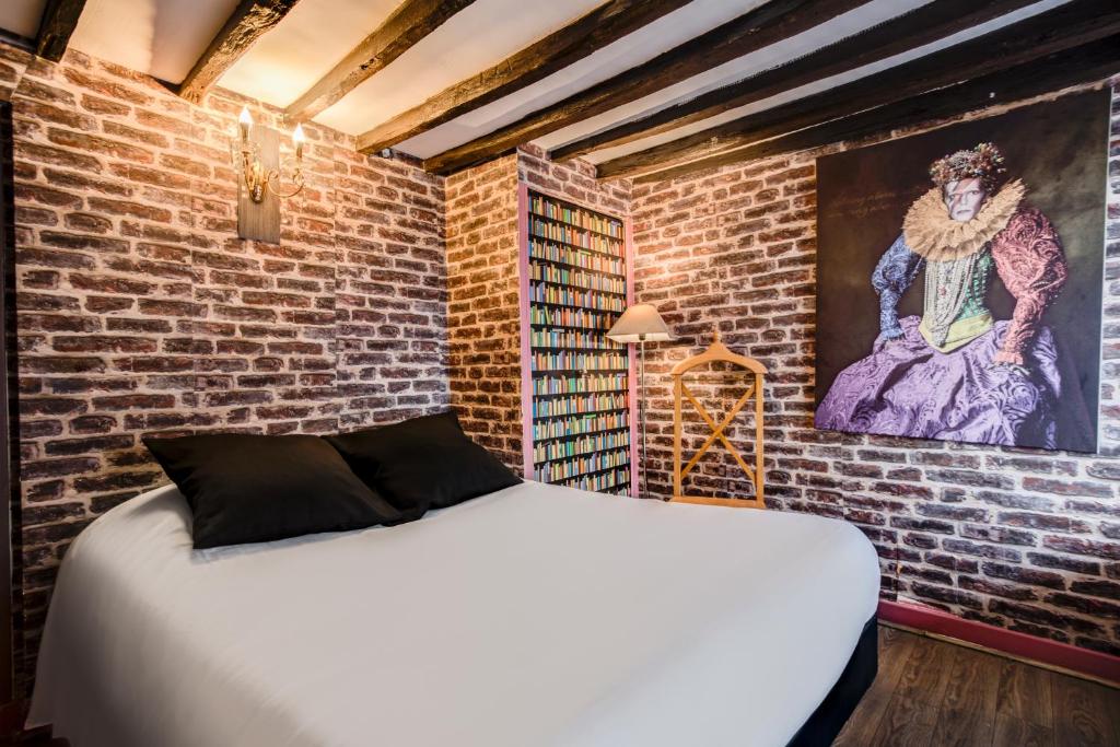 bed in hotel room with brick walls and large art painting