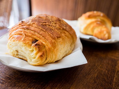 croissant and almond pastry on wood table