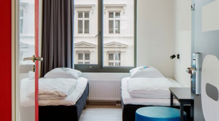 white twin beds near window in hotel room