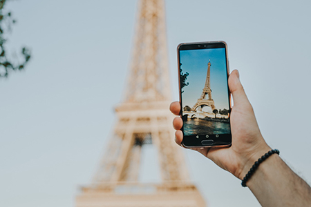 person taking smartphone picture of Eiffel Tower