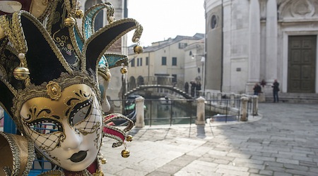 close-up of ornate mask with Venice canals in the background