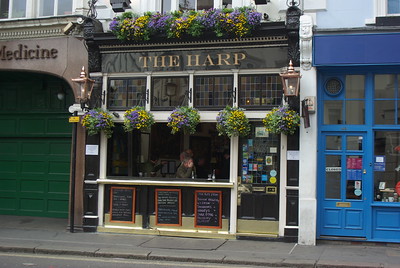 The Harp pub exterior with chalkboard signs and hanging pots of flowers