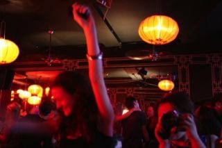 people dancing under dark red lights at Drunken Monkey