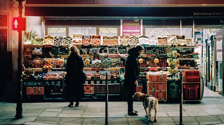 people looking at produce outside supermarket
