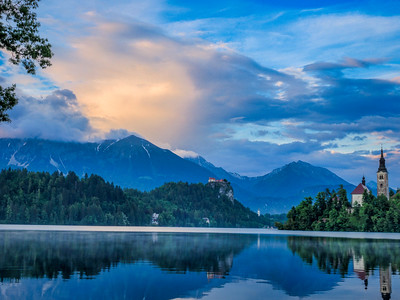 pink clouds at sunset over lake and mountain landscape
