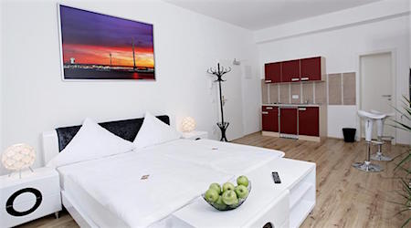 white hotel room with sunset art print over bed