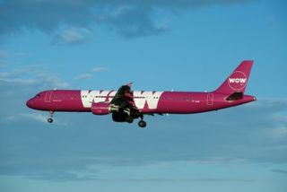 purple WOW Air plane in sky
