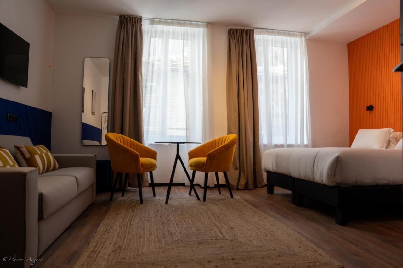 white and orange room with bed and sofa in ClapClap Hotel