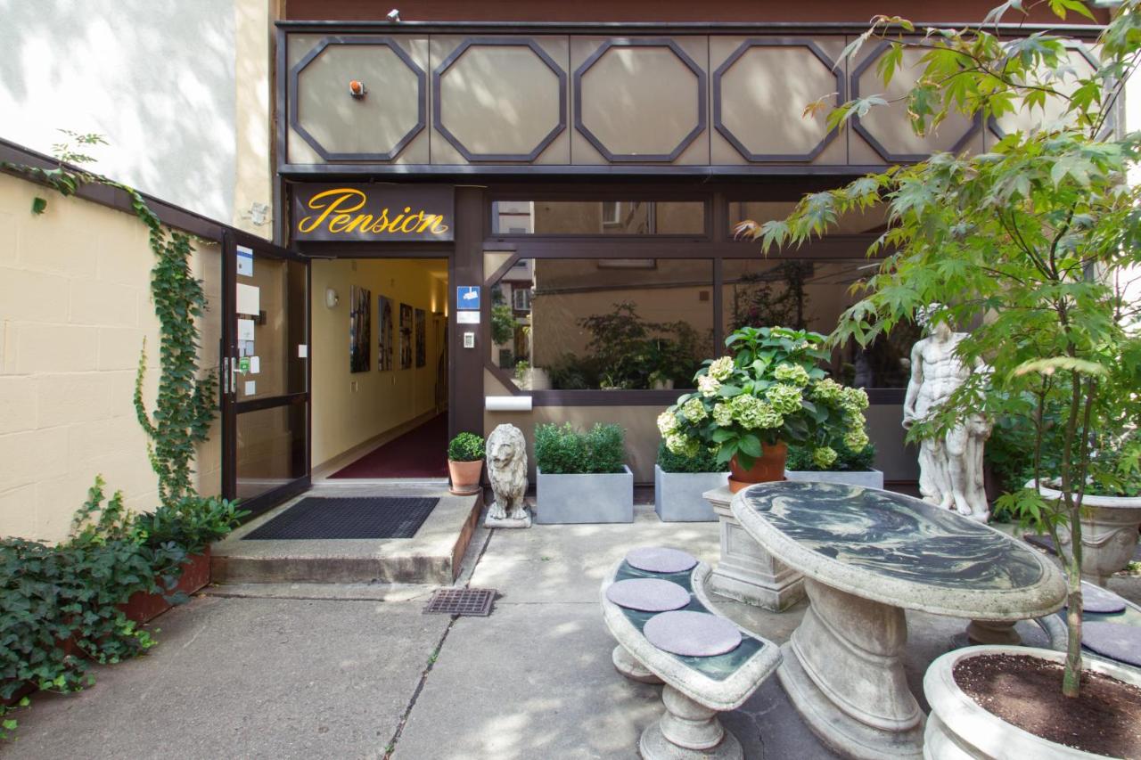 a marble table and sculpture and plants in courtyard at Pension Pharmador