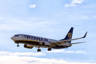 Ryanair plane flying through blue skies