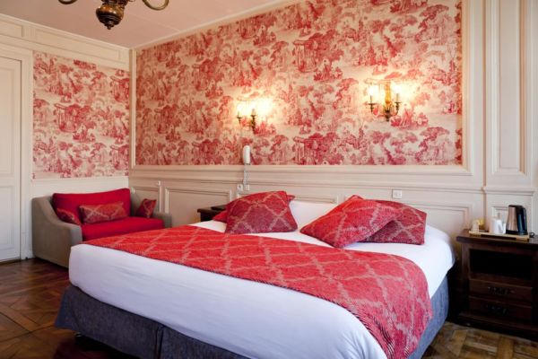 red hotel room with patterned wallpaper