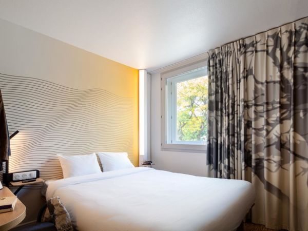 white hotel room with patterned curtain
