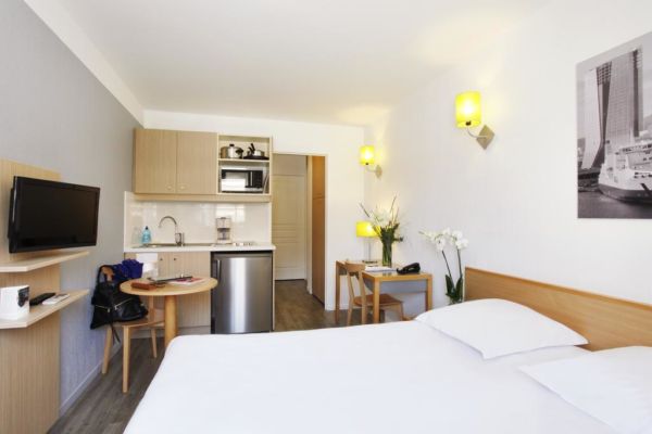 studio hotel room with bed and kitchenette