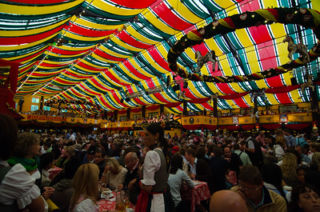 colorful tent packed with people drinking beer