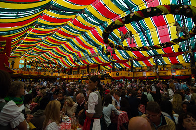 colorful tent packed with people drinking beer