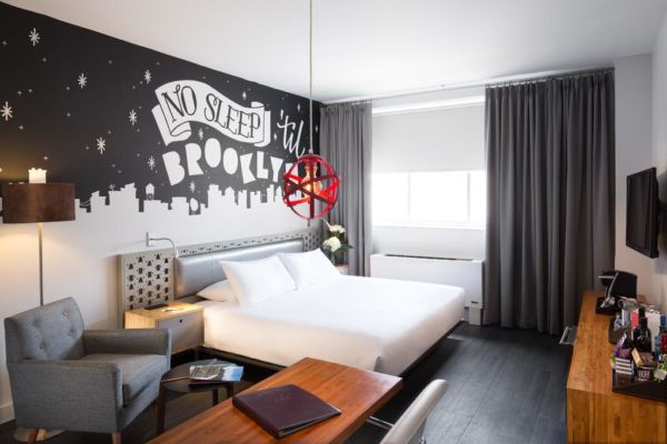 hotel room with white, black and gray decor and Brooklyn wall mural