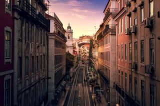narrow street flanked by old buildings in Lisbon
