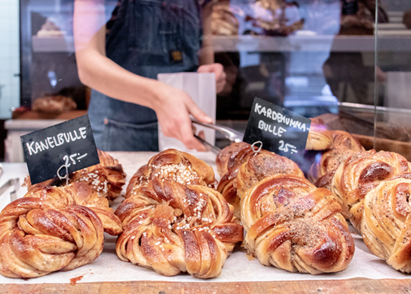 person grabbing sweet bread from display case