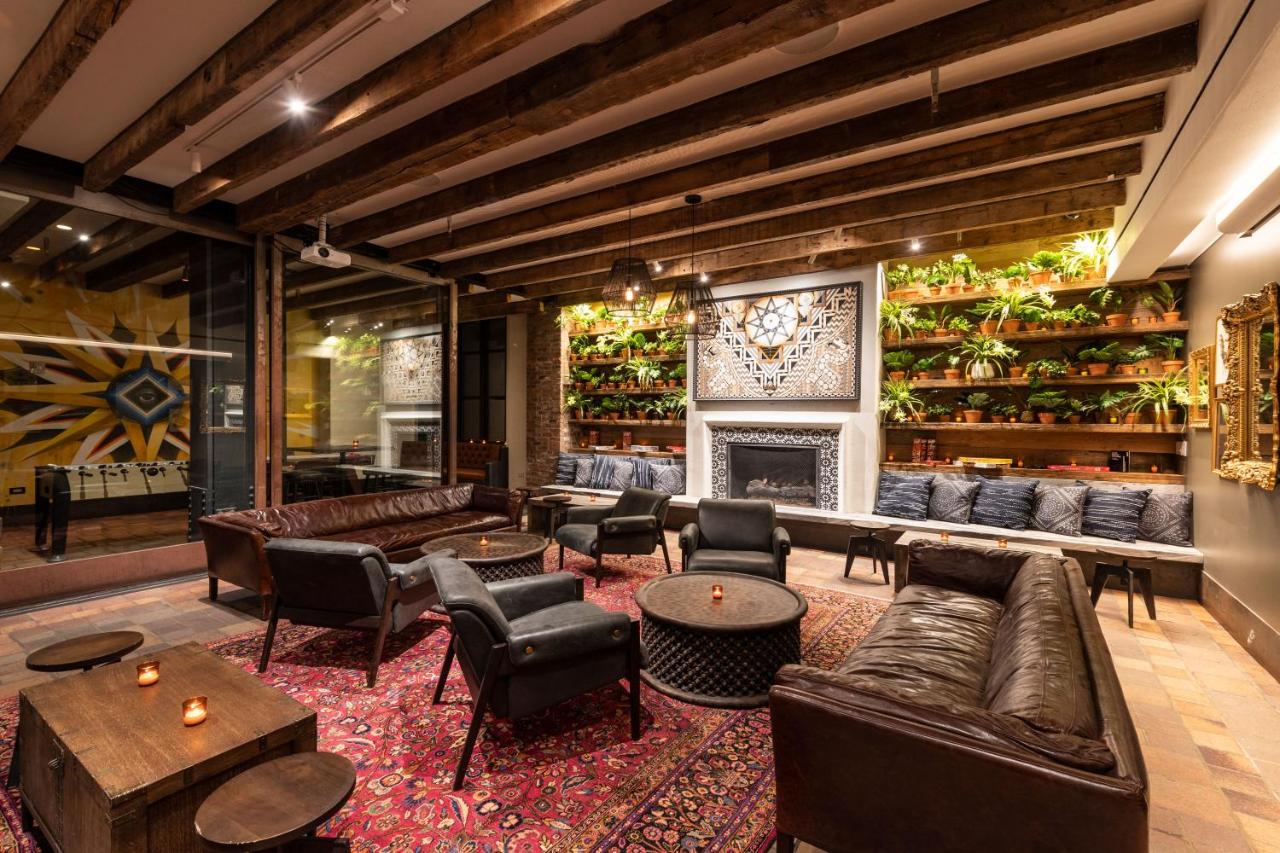 dimly lit lounge with plant-covered wall and leather furniture at budget hotel Pod 39