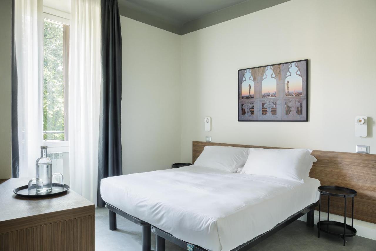hotel room with white walls, white bedding, and large window